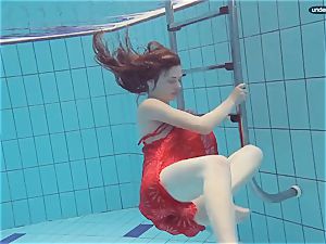 red dressed teenage swimming with her eyes opened